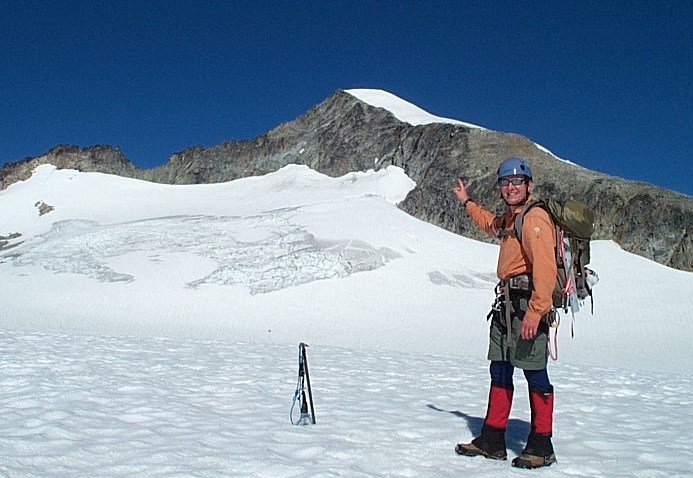 On the snowfield, pointing to summit